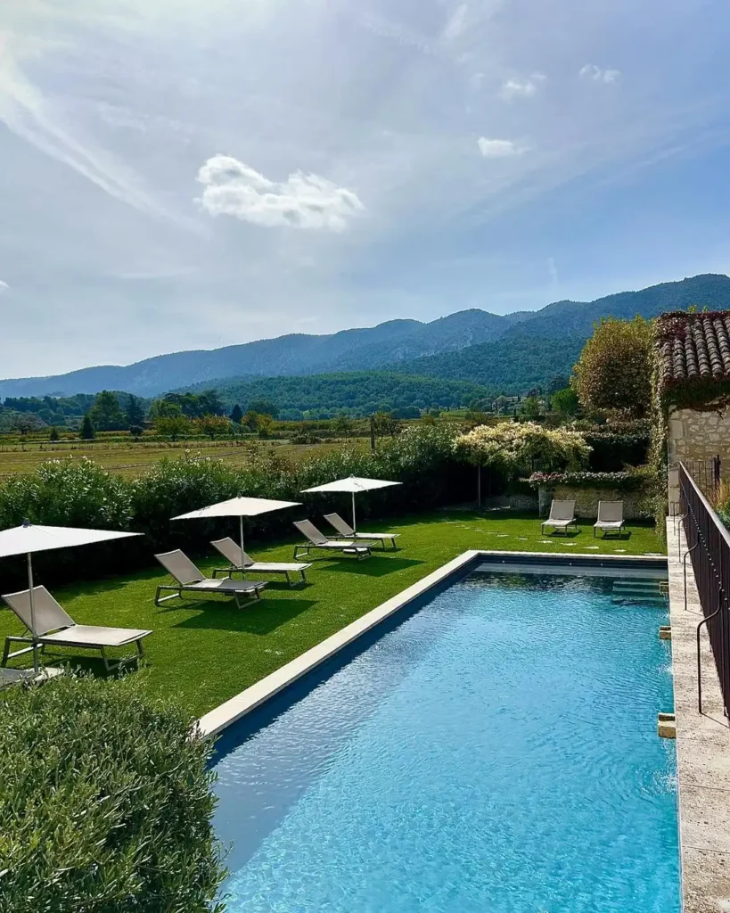 Piscine avec jardin engazonné, espace détente et vue panoramique sur le massif du Luberon