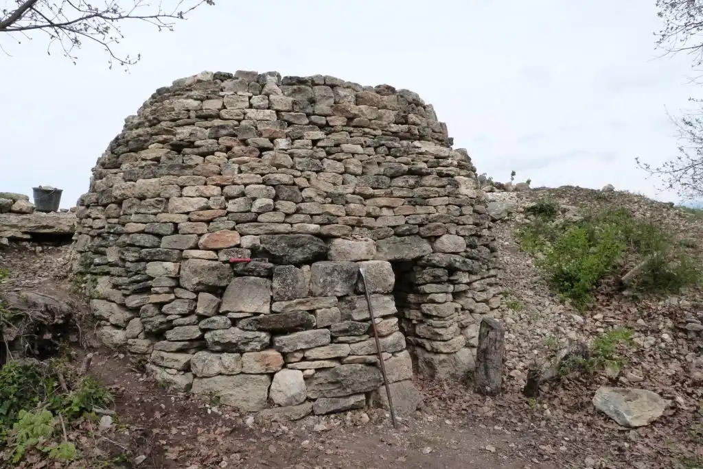 Cabane en pierre sèche de type borie dans un paysage provençal