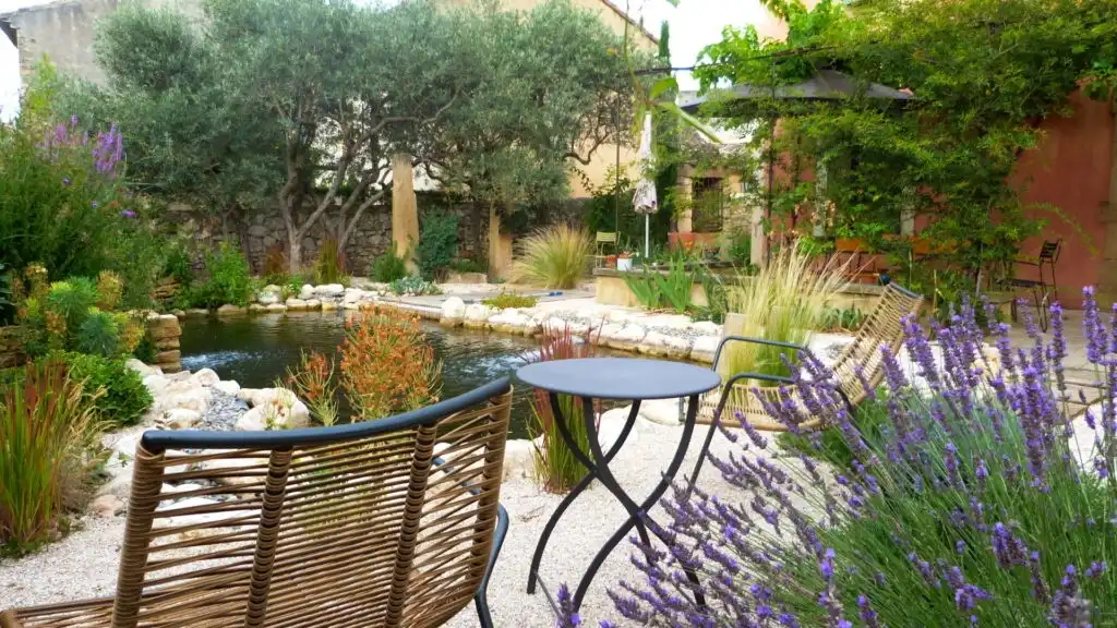 Coin détente dans un jardin méditerranéen avec bassin, lavande et mobilier extérieur