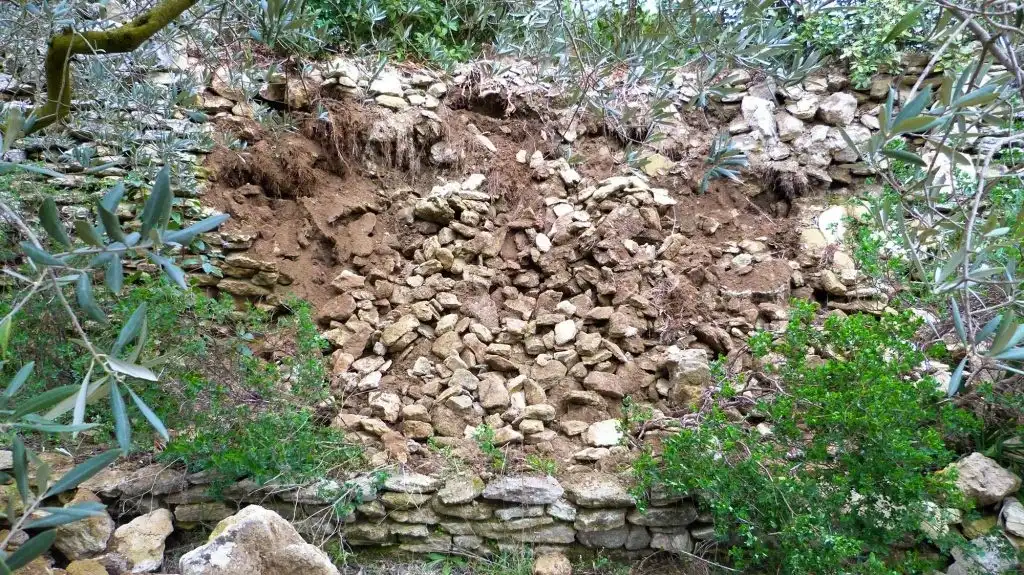 Effondrement d’un muret en pierre sèche avec érosion du terrain en milieu naturel