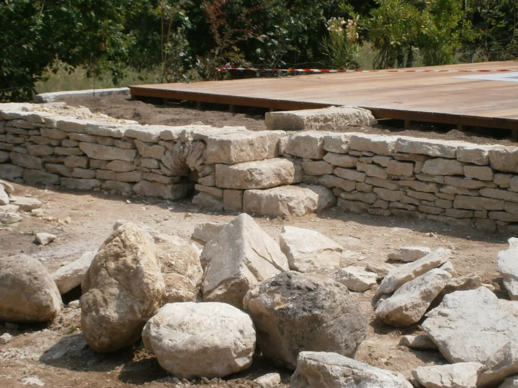 Construction d’un mur de soutènement en pierre sèche avec escalier intégré près de la terrasse de piscine à Maubec